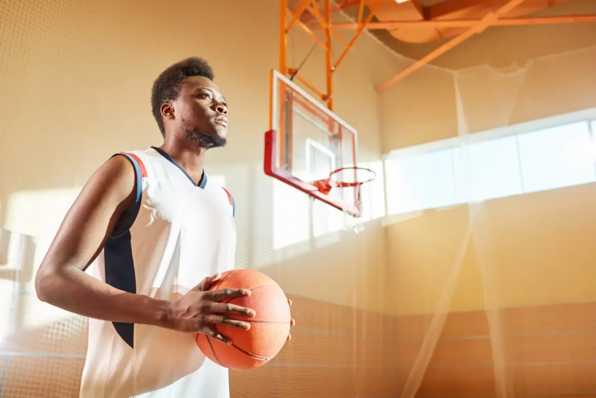 Basketball player holding a ball in a gym