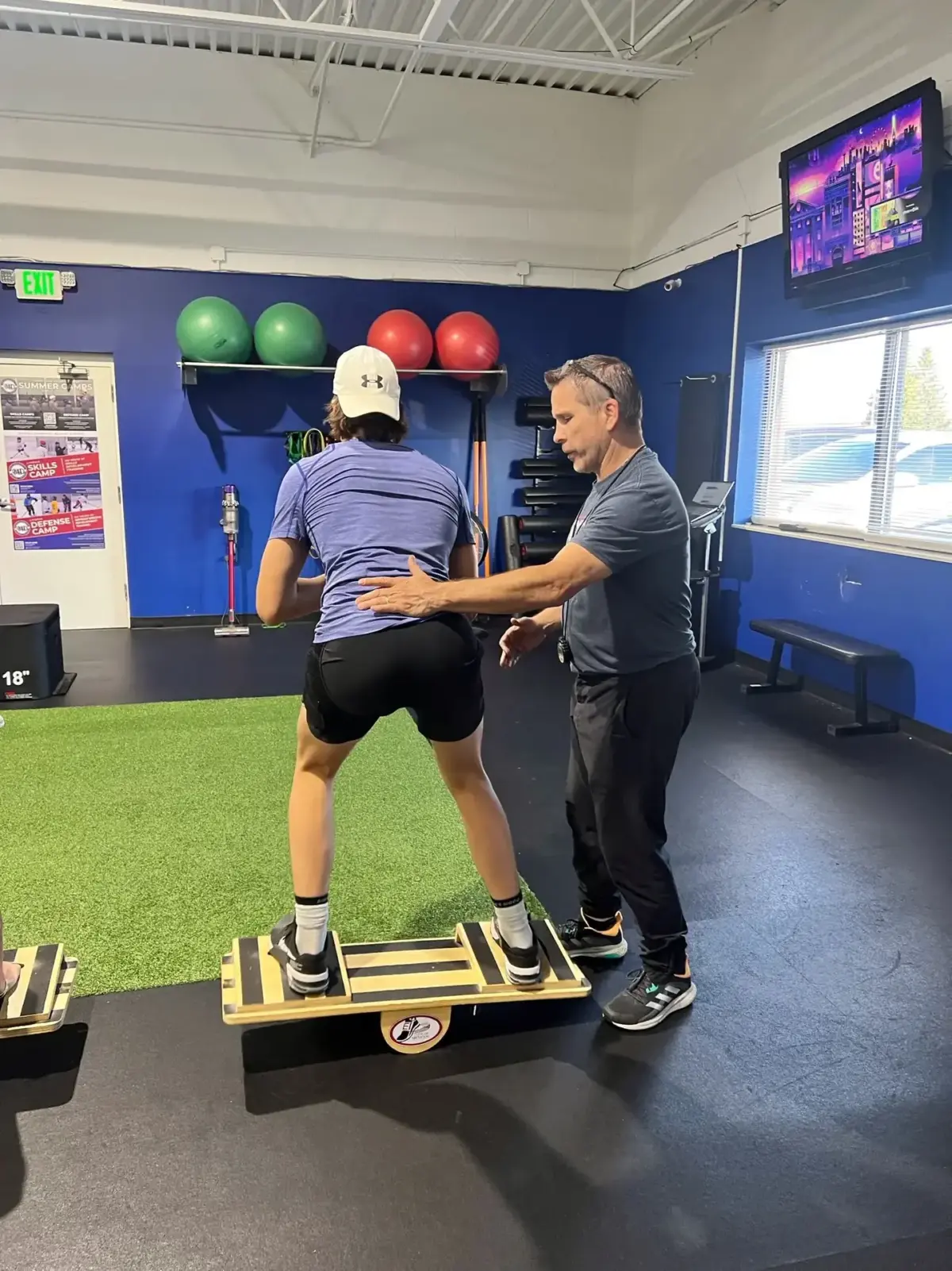 Exercise Innovation coach guiding an athlete through balance board training in a one-on-one session