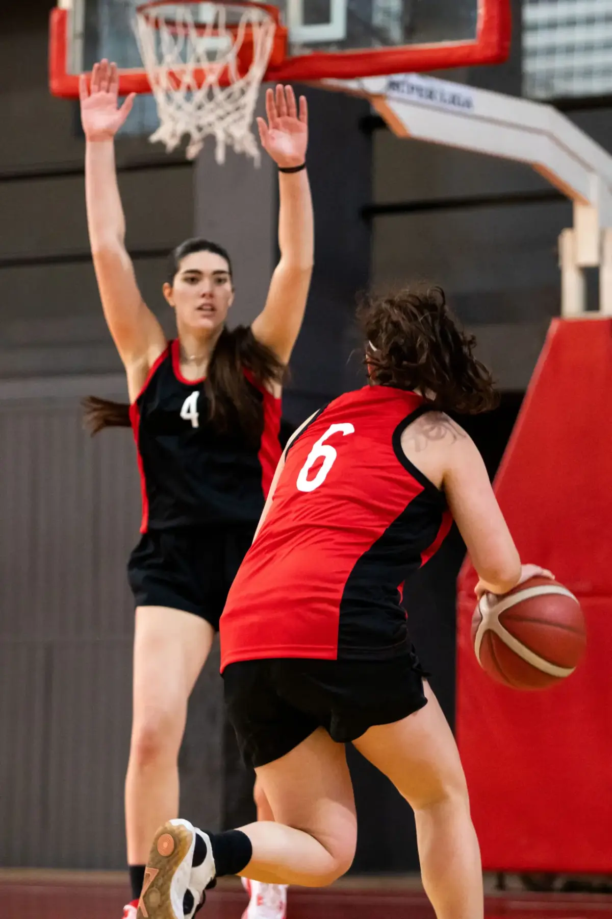Girls basketball player driving to the basket past a defender