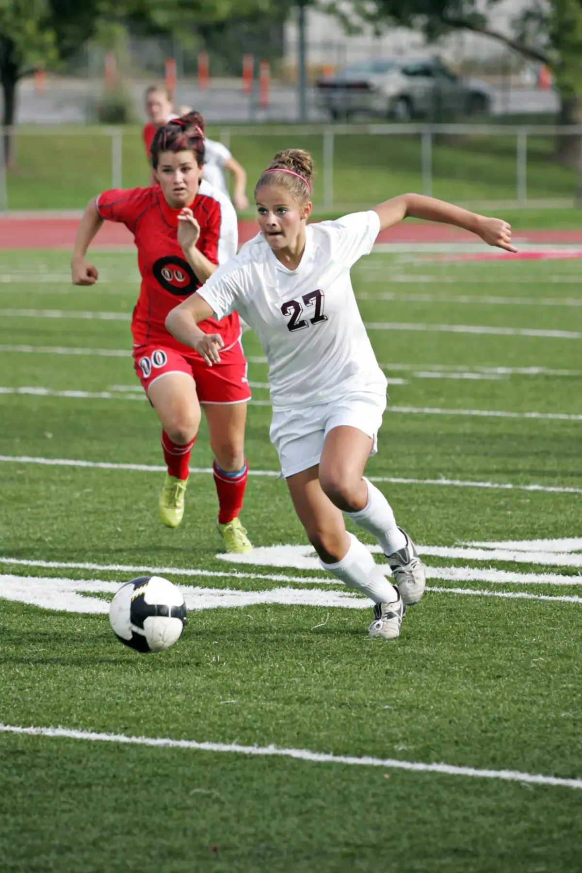 Two youth soccer players racing for the ball during a match
