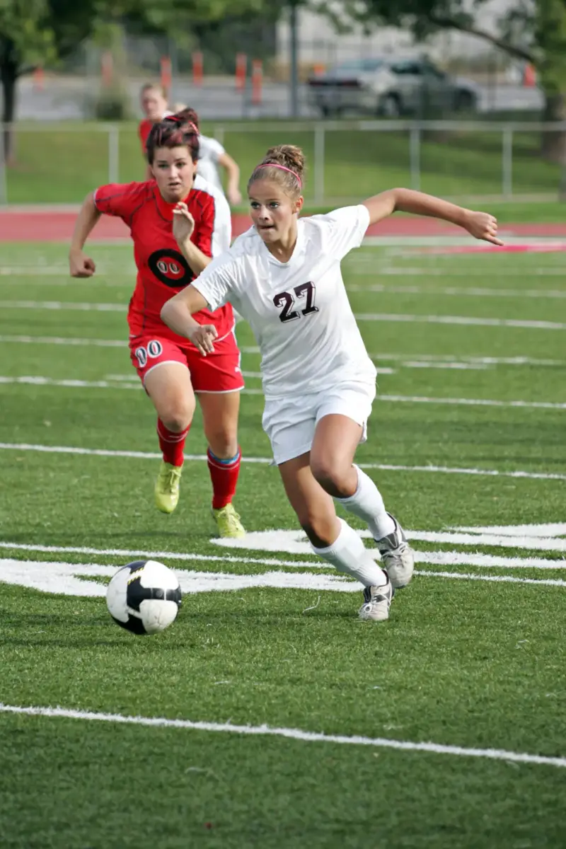 Two youth soccer players racing for the ball during a match