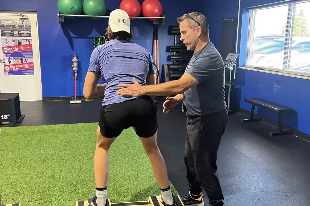 Exercise Innovation coach guiding an athlete through balance board training in a one-on-one session